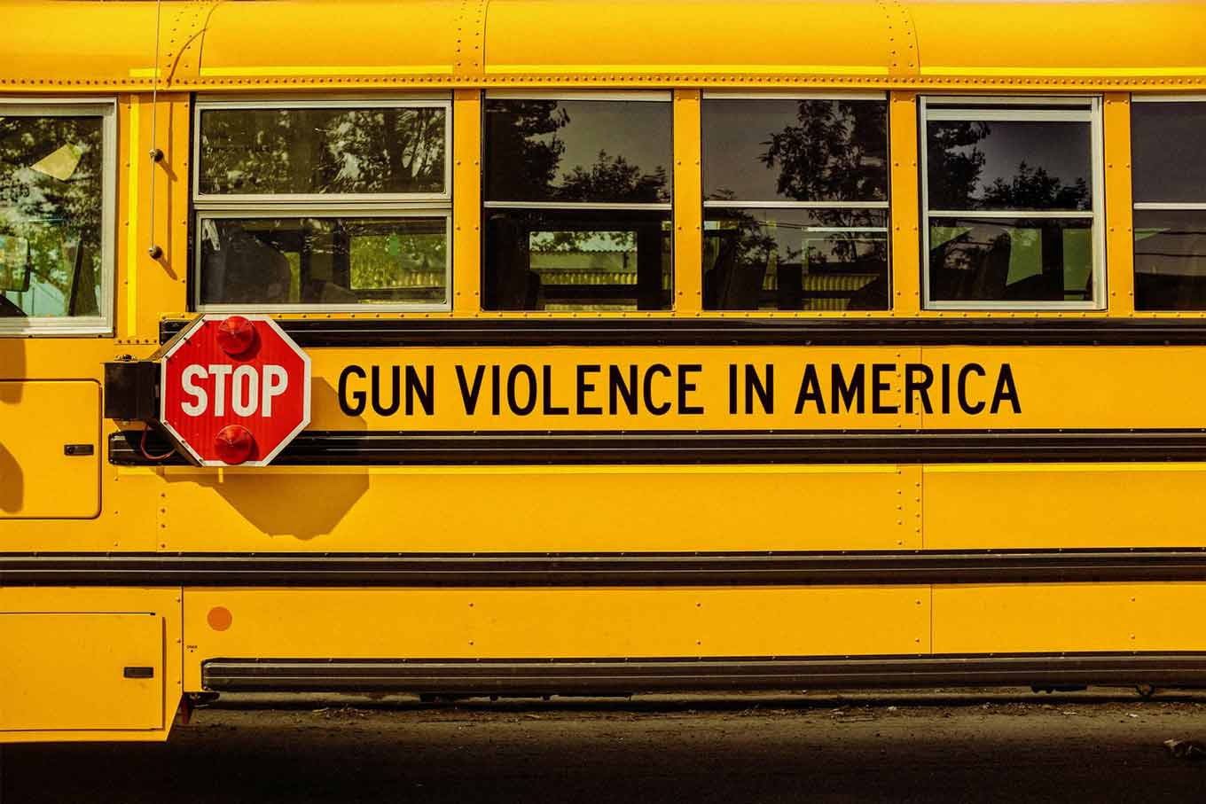 Een gele schoolbus met de tekst STOP wapengeweld in Amerika