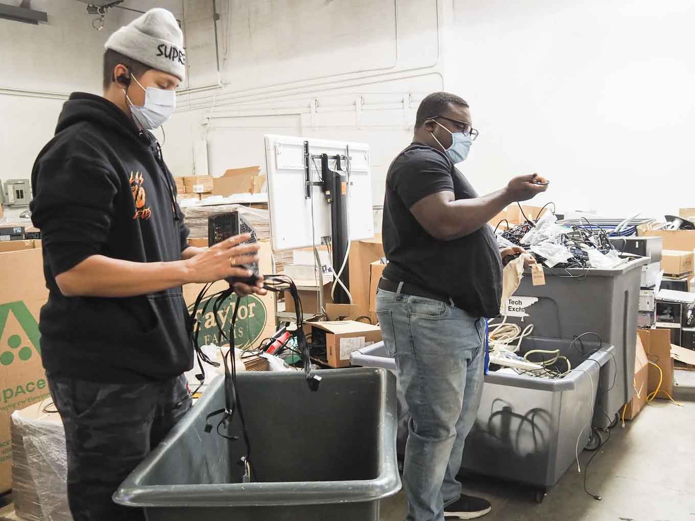 Het magazijnpersoneel van Tech Exchange sorteert gedoneerde apparatuur. Zij en hun Tech Hub-collega's werkten maandenlang aan #OaklandUndivided apparaten die vervolgens in 2020 en 2021 aan studenten werden gedistribueerd.