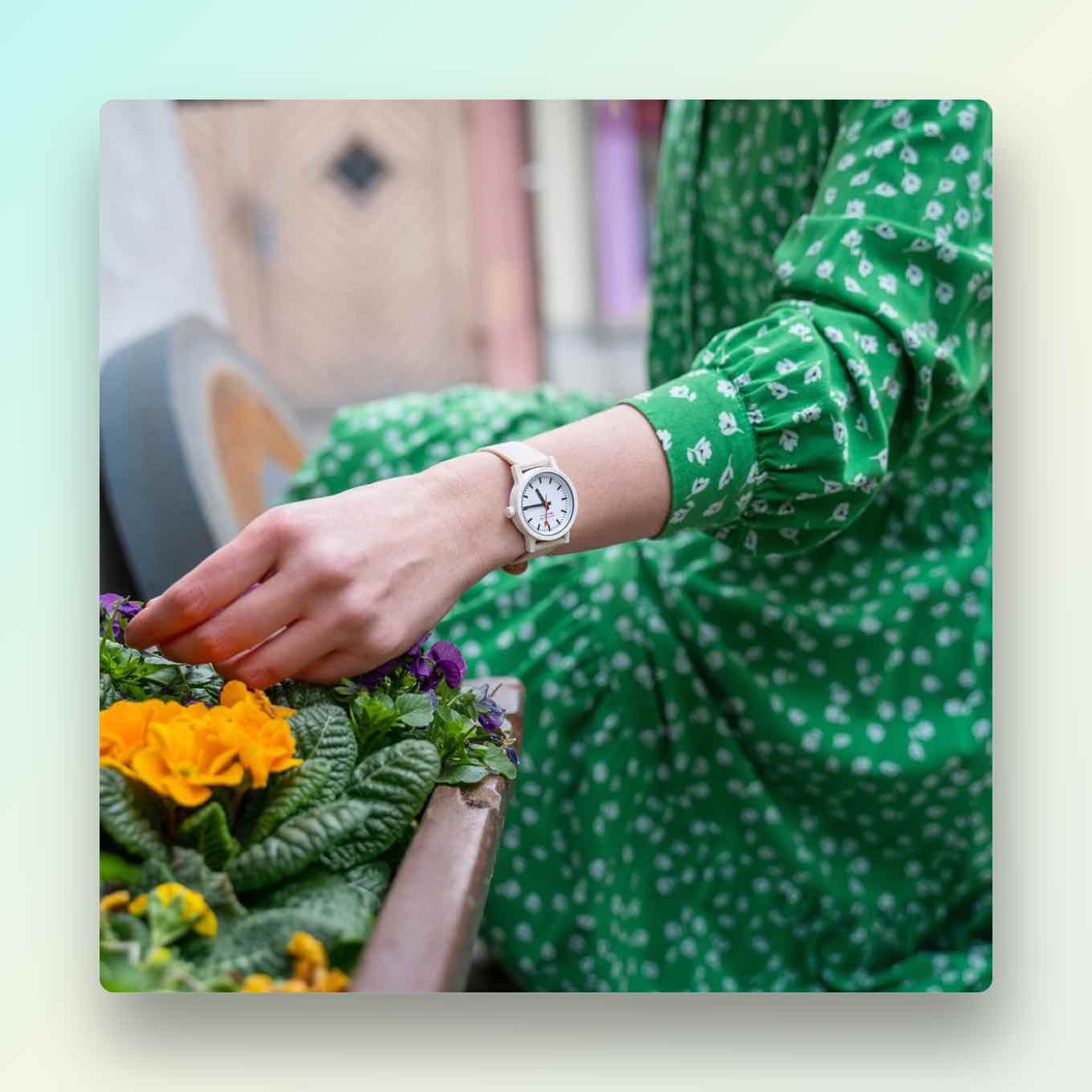 Vrouw die milieuvriendelijk horloge draagt tijdens het tuinieren in een groene jurk