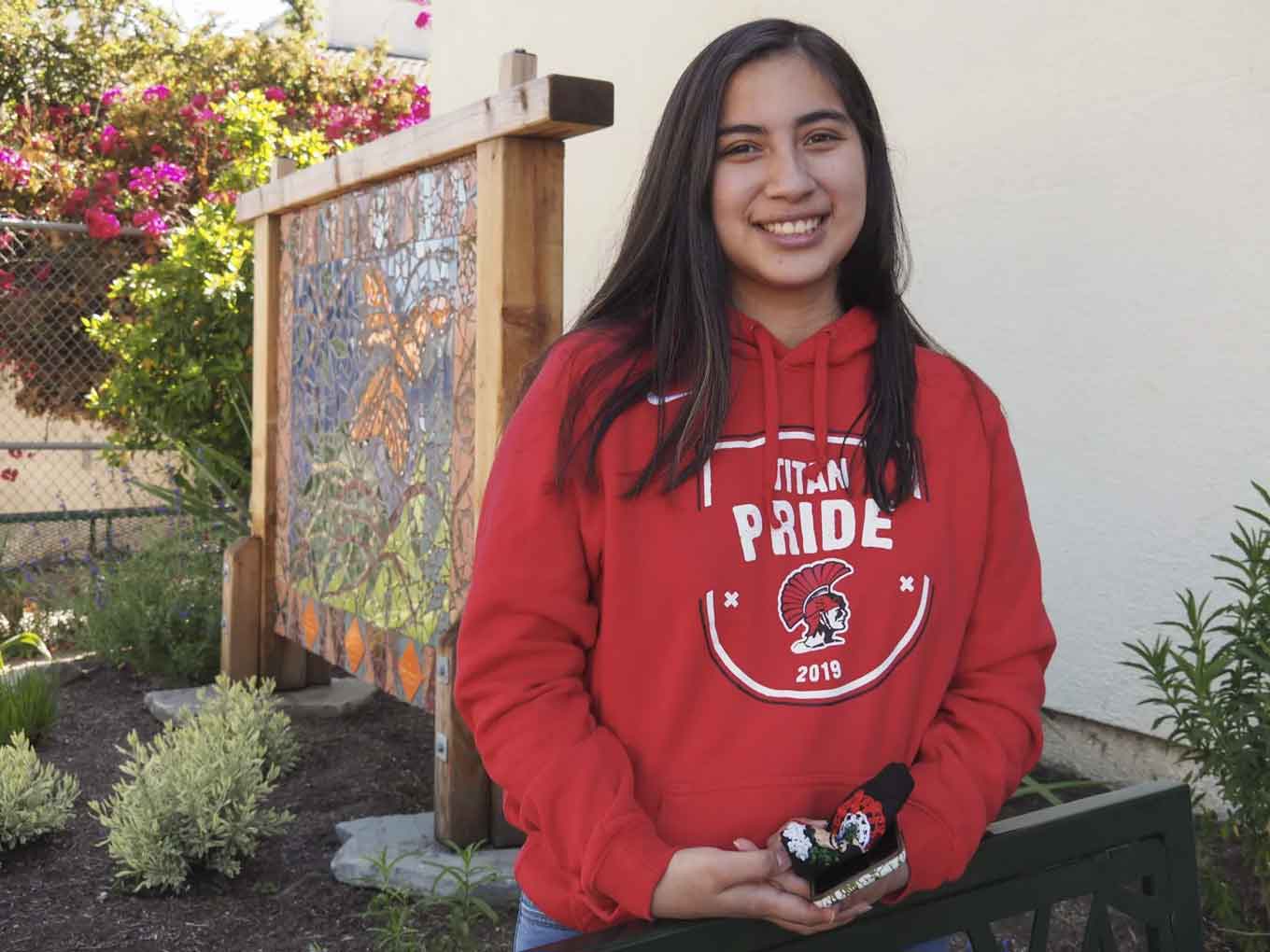 Een eerstejaars bij UC Berkley draagt een rode "Tital Pride" sweatshirt en glimlach voor de camera