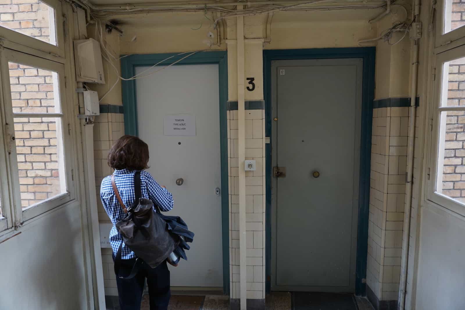 Een vrouw staat voor twee deuren in het Parijse volkshuis Marcadet