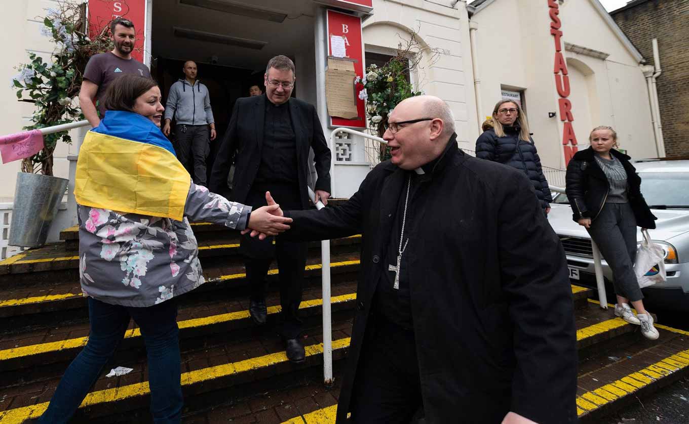 Een katholieke priester verwelkomt een Oekraïense vluchteling