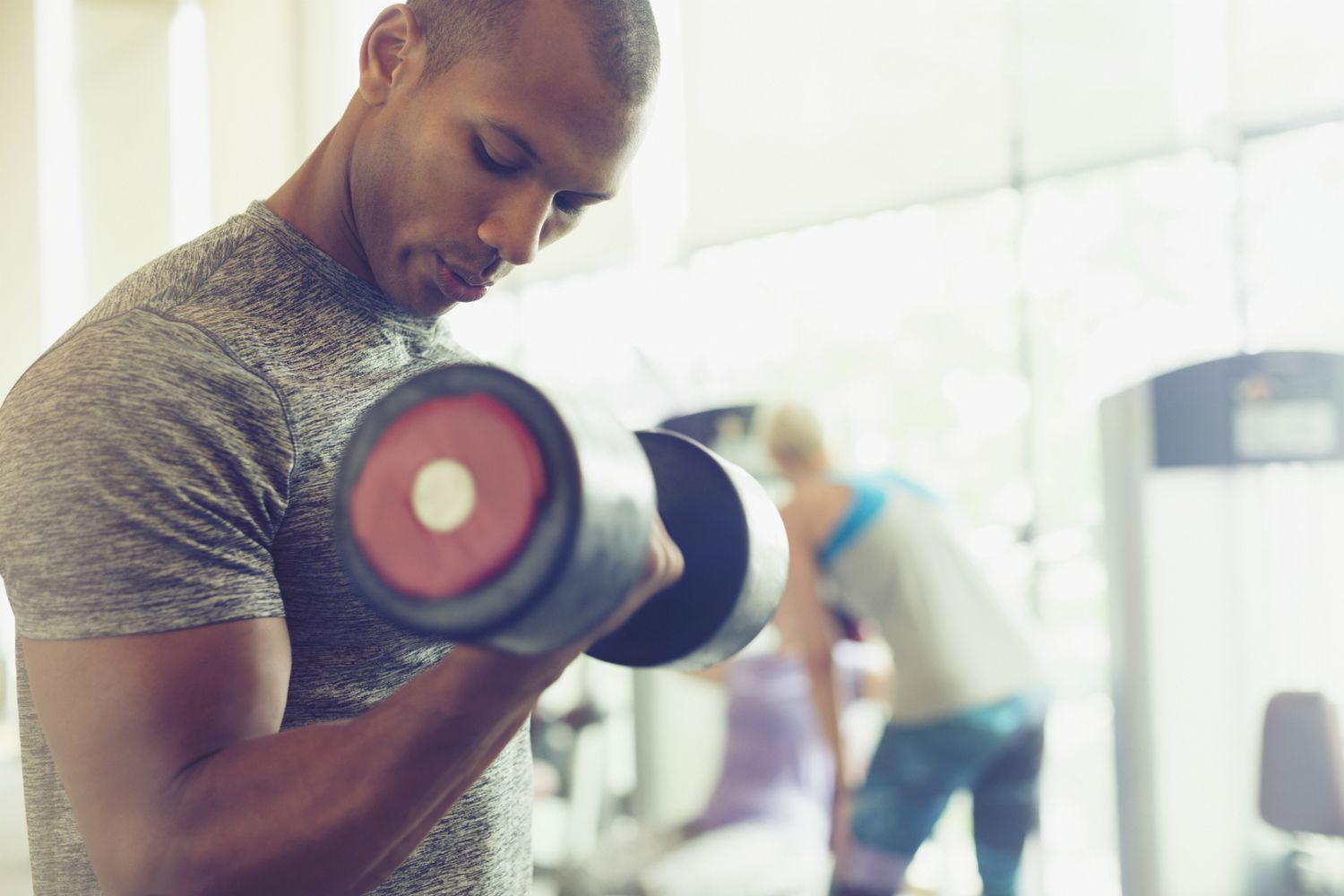 Afro-Amerikaanse man die halter vasthoudt in de sportschool