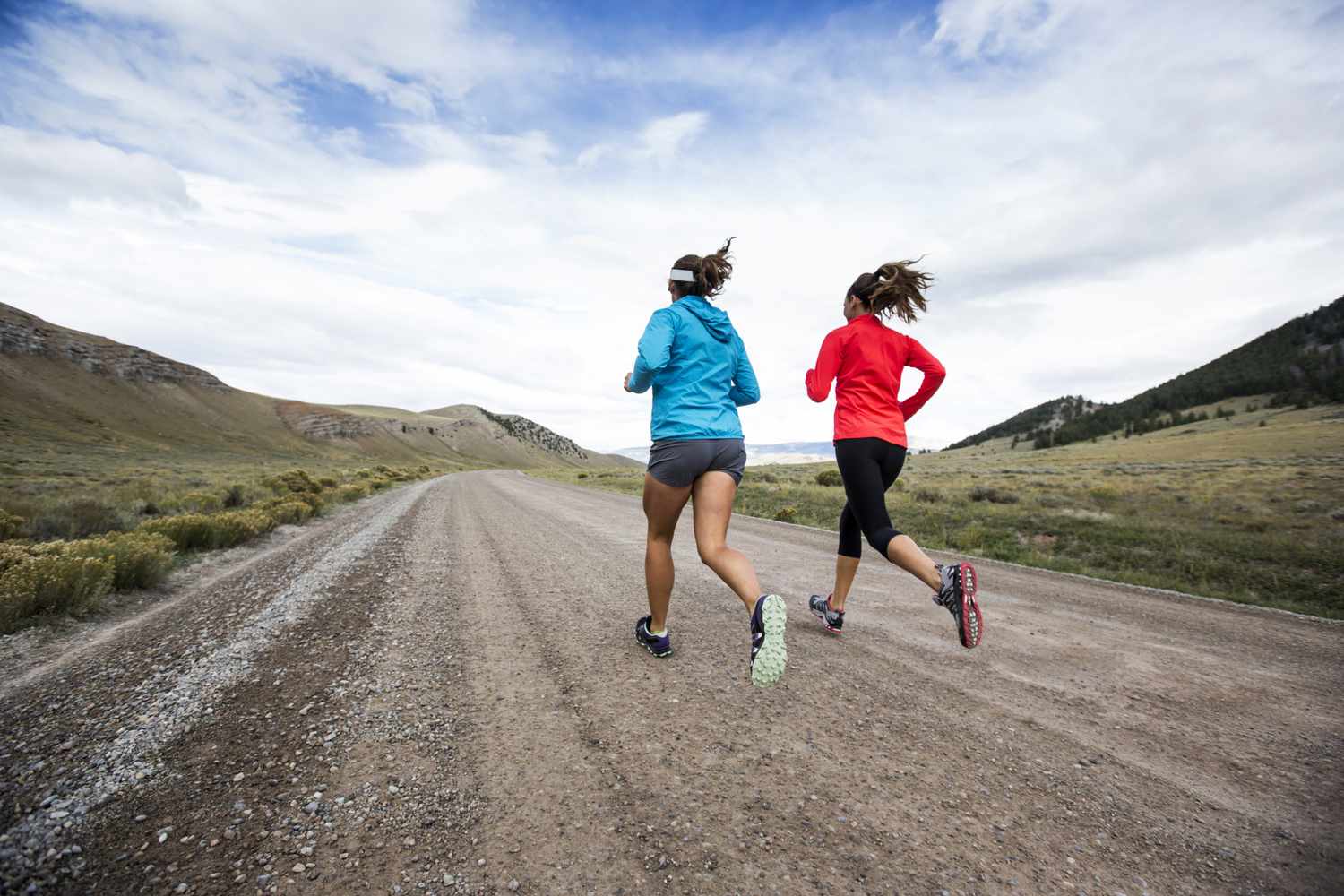 Twee vrouwen die op onverharde weg rennen